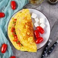 Fried omelette with beef, tomato, onion and herbs. Delicious breakfast with scrambled eggs. Top view Royalty Free Stock Photo