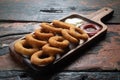 Fried onion rings with ketchup and mayonnaise on rustic wooden table Royalty Free Stock Photo