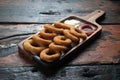 Fried onion rings with ketchup and mayonnaise on rustic wooden table Royalty Free Stock Photo