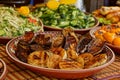 Fried onions and fried eggplants in a plate on a table with other dishes