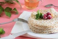 Fried pancakes close-up on a white plate, pancakes with raspberries, tea cerimonia, dessert on a pink background