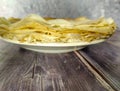 Fried pancakes in a white plate on a wooden table. Side view Royalty Free Stock Photo