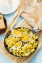 Fried pasta with boiled eggs, cheese and chives