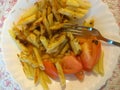 Fried pasta with sauce and fresh tomatoes on a white plate. Fork for food. Home Cooking. Cut out the expense. Simple recipe. Budge