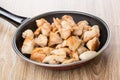 Fried pieces of chicken meat in frying pan on table Royalty Free Stock Photo