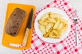 Fried pieces of potato, fork, loaf of bread, knife Royalty Free Stock Photo