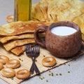 Fried pies, cheese, sunflower oil, milk and bagels on a plate cl