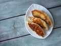 Fried pies on a white figurine plate on a wooden plank tray