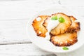 Fried pineapple slices with creme fraiche, white table. Copy space