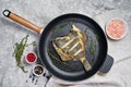 Fried plaice in a pan. Gray background, top view.