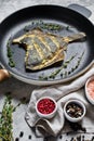 Fried plaice in a pan. Gray background, top view. Royalty Free Stock Photo
