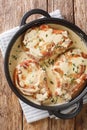 Fried pork chops stewed in a creamy wine sauce with thyme close-up in a pan. Vertical top view Royalty Free Stock Photo