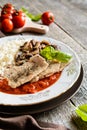 Fried pork cutlets with rice, tomato and mushrooms