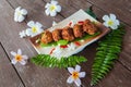 Fried pork with garlic and pepper on a plate on wooden floor Royalty Free Stock Photo