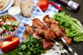 fried pork kebab on skewers lies on the table with vegetables