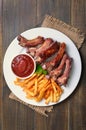 Fried pork ribs, potato fries and tomato sauce, top view Royalty Free Stock Photo