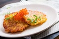 Fried potato pancakes with red caviar and sour cream fritter roesti.