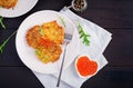 Fried potato pancakes with red caviar and sour cream fritter roesti.