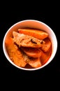 Fried potato slices in herbs gravy or Kashmiri Dum Aloo, traditional north indian curry,isolated on black background. Top view