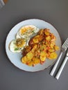 Fried potatoes with bacon cubes and fried eggs Royalty Free Stock Photo