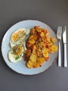 Fried potatoes with bacon cubes and fried eggs Royalty Free Stock Photo