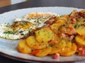 Fried potatoes with bacon cubes and fried eggs Royalty Free Stock Photo