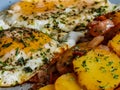 Fried potatoes with bacon cubes and fried eggs Royalty Free Stock Photo