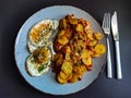 Fried potatoes with bacon cubes and fried eggs Royalty Free Stock Photo