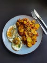 Fried potatoes with bacon cubes and fried eggs Royalty Free Stock Photo