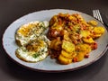 Fried potatoes with bacon cubes and fried eggs Royalty Free Stock Photo