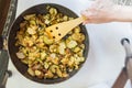 Fried potatoes with onion and cucumber in iron pan