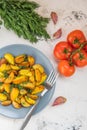 Fried potatoes in a plate. Baby potatoes, green, tomatoes and ga