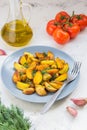 Fried potatoes in a plate. Baby potatoes, green, tomatoes and ga