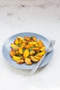 Fried potatoes in a plate. Baby potatoes, green, tomatoes and ga