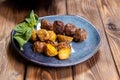 Fried potatoes in a uniform and meat cutlets in a plate with greens