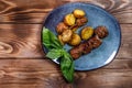 Fried potatoes in a uniform and meat cutlets in a plate with greens