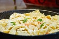 Fried prawns with Italian pasta called mafaldine, Parmesan cheese and herbs in a pan Royalty Free Stock Photo