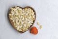 Fried pumpkin seeds on heart shaped wooden bowl