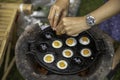 Fried Quail eggs pancake on pothole pan Thai appetizer at street food market Thailand.Thai desserts and snack meal.cavity,pit