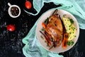 Fried rabbit leg, garnish of boiled potatoes, grilled carrots - on a plate on a dark background Royalty Free Stock Photo