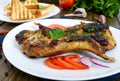 Fried rabbit legs on a white plate on a wooden table. Dietary rabbit meat Royalty Free Stock Photo