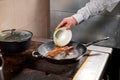 Fried ribs of lamb. Cooking with fire in frying pan. Professional chef in a kitchen of restaurant cooking. Man frying Royalty Free Stock Photo