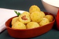 Fried rice balls called bolinho de arroz with one open stuffed with sausage