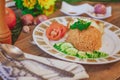 Fried Rice with Fried Egg Put on the wooden table and the tomatoes, cucumbers, garlic, shallots. Royalty Free Stock Photo