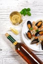 Fried rice with seafood mussels, shrimps and basil in a plate with wine bottle and wineglass on white cracked wooden table Royalty Free Stock Photo