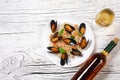 Fried rice with seafood mussels, shrimps and basil in a plate with wine bottle and wineglass on white cracked wooden table Royalty Free Stock Photo