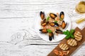 Fried rice with seafood mussels, shrimps and basil in a plate with wineglass and toasted baguette on white cracked wooden table Royalty Free Stock Photo