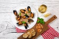Fried rice with seafood mussels, shrimps and basil in a plate with wineglass, towel and toasted baguette on white cracked wooden t Royalty Free Stock Photo