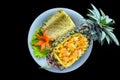 Fried rice with seafood in a pineapple with vegetables on blue plate isolated on black background top view Royalty Free Stock Photo