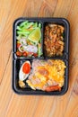 Fried rice with shrimp paste include mango, egg, pork, onion, vegetable in box black Thai style food on a wood table background